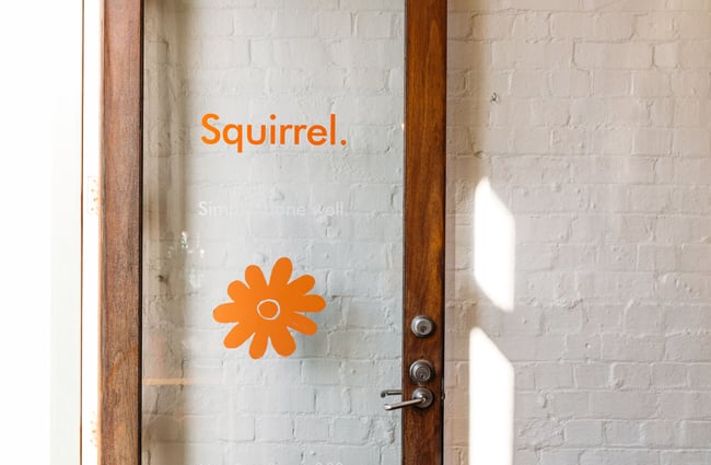The word 'Squirrel' and a flower on a glass door.