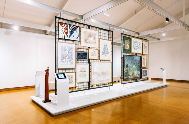 The bright gallery interior with wooden floors and white walls.