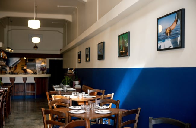 A blue and white painted wall inside an empty restaurant.