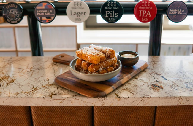 A bowl of polenta fries in front of the beer taps at the bar at The Birdwood.