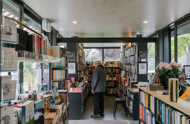 Man browsing the books at The Next Chapter, Wānaka.