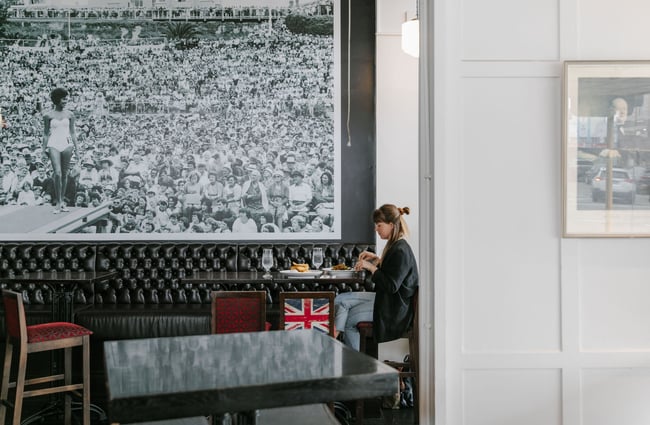 A woman eating a meal underneath a huge black and white photo on a wall at The Oxford restaurant in Timaru.