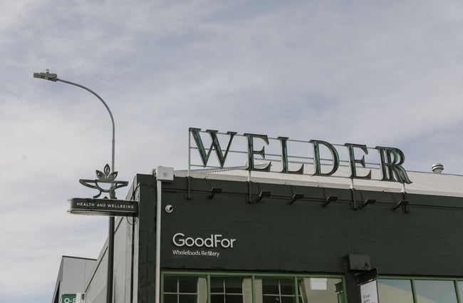 The green exterior Welder sign above the black building.