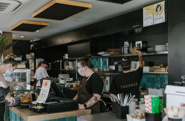 Person serving a customer at the till at Truffle café, Christchurch.