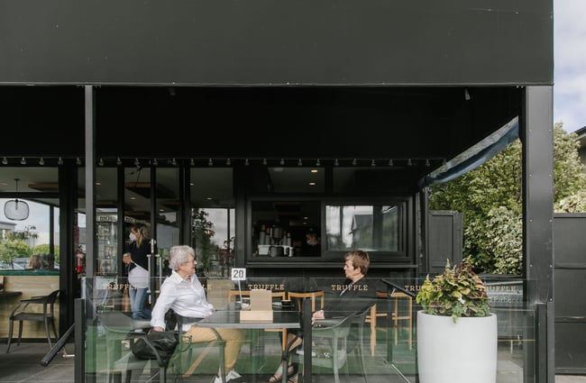 Two woman having a coffee on the veranda at Truffle café, Christchurch.