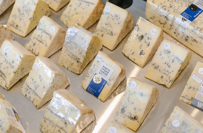 A close up of blue Whitestone cheeses on display.
