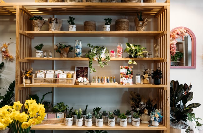 Items for sale displayed on wooden shelves.