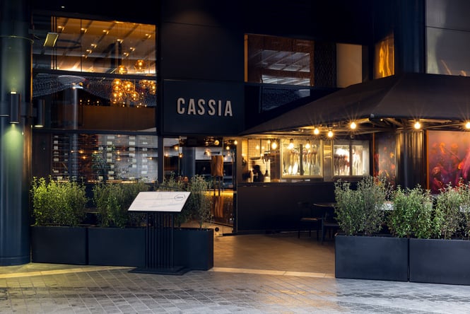The black entrance to Cassia restaurant on a rainy day.