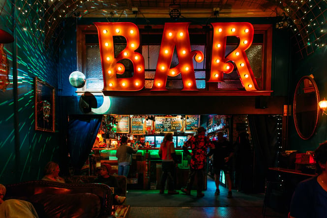 A massive sign that says 'Bar' inside Common Room in Hastings.