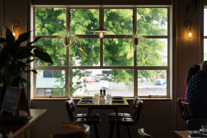 A table setting underneath a window looking out towards a sunny Rotorua street.