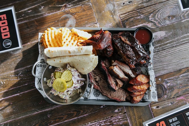 Flatlay of BBQ meat and chips on a table.