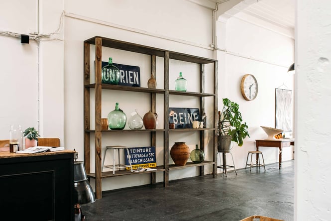 A minimalist display of homewares on a wooden display set against a white wall.