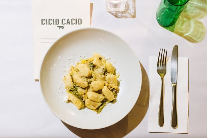 A plate of gnocchi sitting on a white table inside Cicio Cacio Wellington.