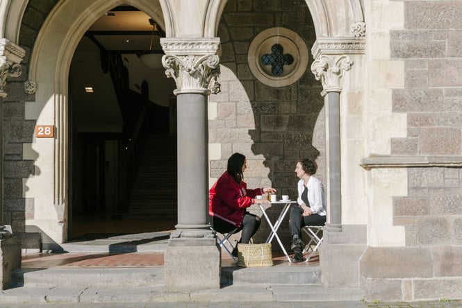 Two people enjoying a coffee under the archway at the Arts Centre Christchurch.