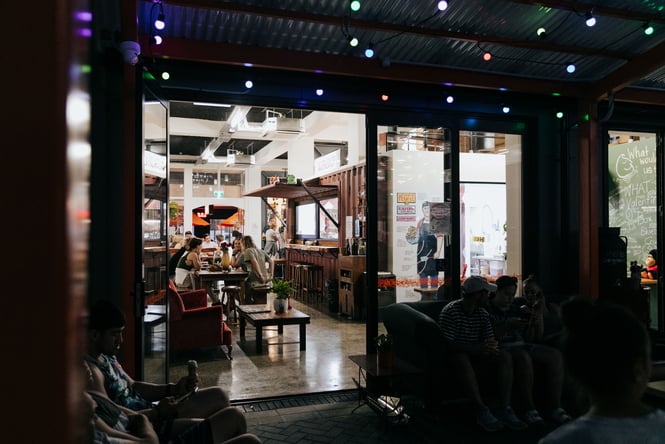 Customers dining inside Rollickin' Gelato at night.