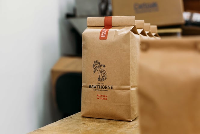 Paper bags of Hawthorne Coffee on a counter.