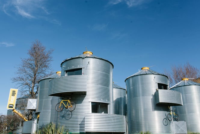 Five tin silo stays at Christchurch accommodation with native Buch around the bottoms.
