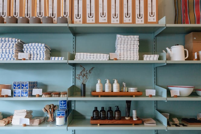 Homewares and skincare products on blue shelves.