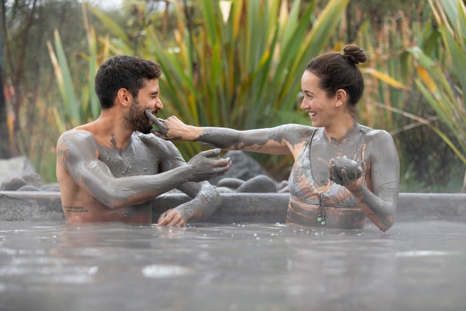 A man and woman having fun with mud at Polynesian Spa in Rotorua.