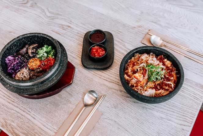 Three bowls of Korean food on a table.