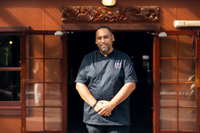 A man in a black chef's outfit posing for camera.
