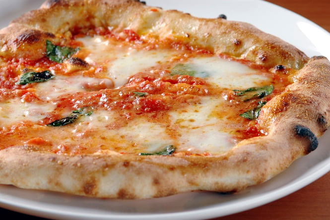 An extreme close up of a margherita pizza.