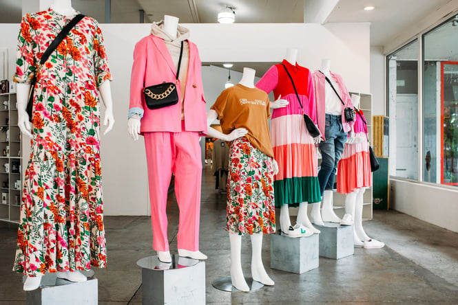 Mannequins dressed in bright colouring of pink and green clothing.
