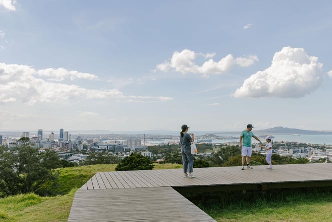 A family playing on the top of Mt Eden on sunny day.