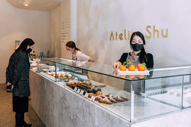 Woman looking at the cakes on display at Atelier Shu in Parnell, Auckland.