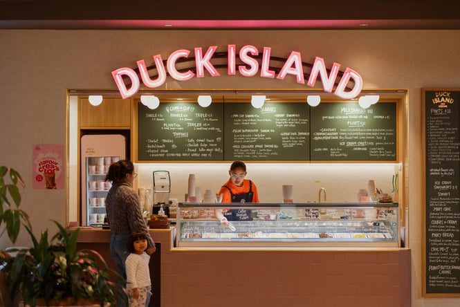 A staff member serving a mother and daughter at Duck Island in Wellington.