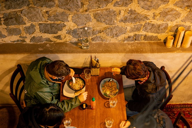 A birds eye view of four people eating at a table.