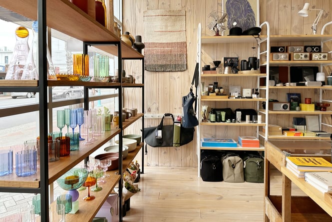 Glassware and homewares on display on wooden shelves.
