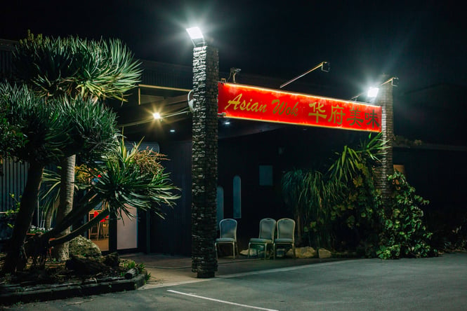 The brightly lit entrance to Asian Wok at night.