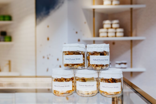 Salted peanut brittle in jars on a counter.