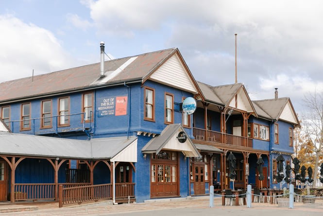 A blue and brown country pub on a sunny day.