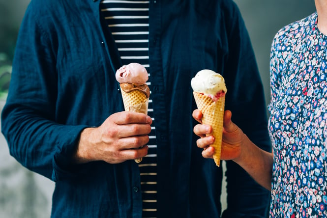 A man and woman holding an ice cream each.