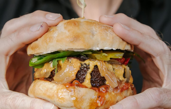 Close up of hands holding a vegan burger.