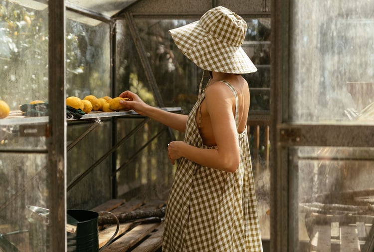 Woman wearing gingham hat and dress from Mina.