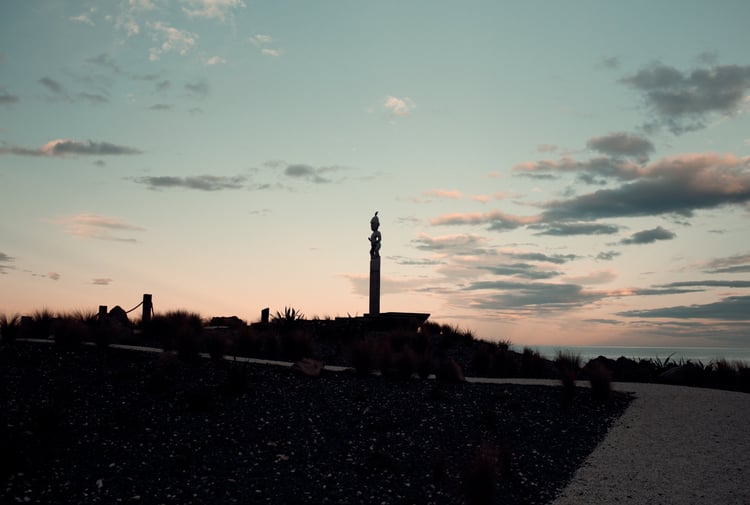 A view of a tall sculpture in Kaikoura at sunset.