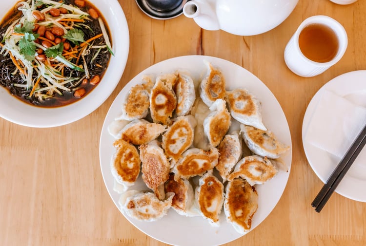 A flatlay of a plate of dumplings on a table.