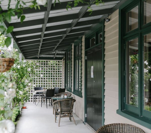 A covered verandah outside Cafe Verde, surrounded by greenery in Geraldine.