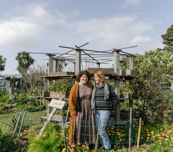 Catherine O’Neill and Lin Klenner smiling in their New Brighton Community Gardens.