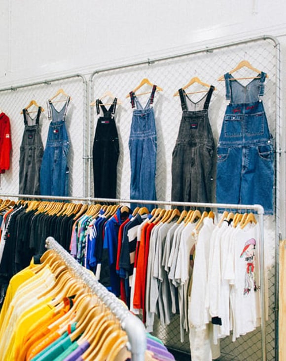 Denim overalls and hats on a wall at Emporium Vintage Boutique Wellington.