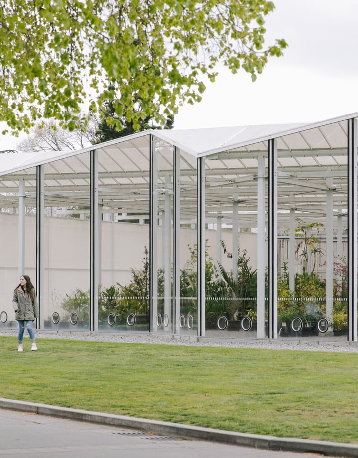 Two people spending time outside a glasshouse at Christchurch Botanic Gardens.