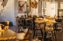 A large cafe with the sun streaming in through its glass windows.