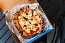 A close up of a delicious looking pizza in a blue box.