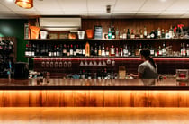 A staff member working behind a bright lit bar at Deliciosa.