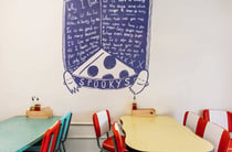 A fun looking menu surrounded by illustrated ghosts on a wall at Spooky's Hastings.