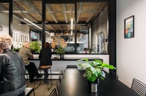 Customers sitting at high black tables inside the cafe.