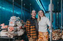 Kimi and Zane standing next to their fungi smiling to camera.